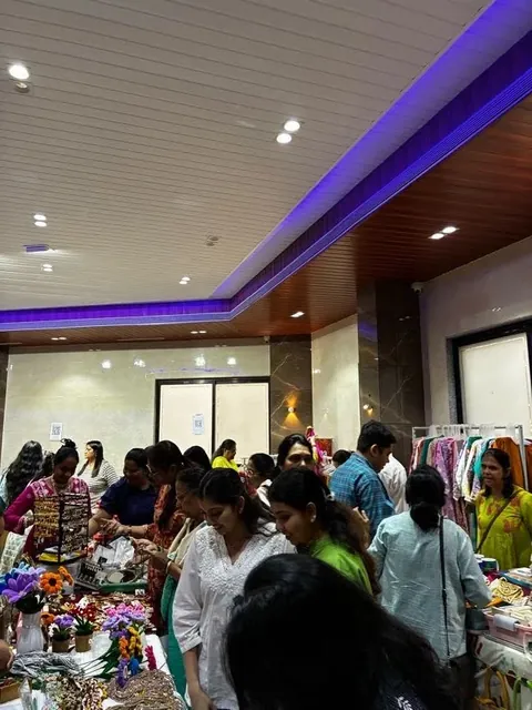 Shoppers browsing stalls of clothes and handmade goods at a festive exhibition